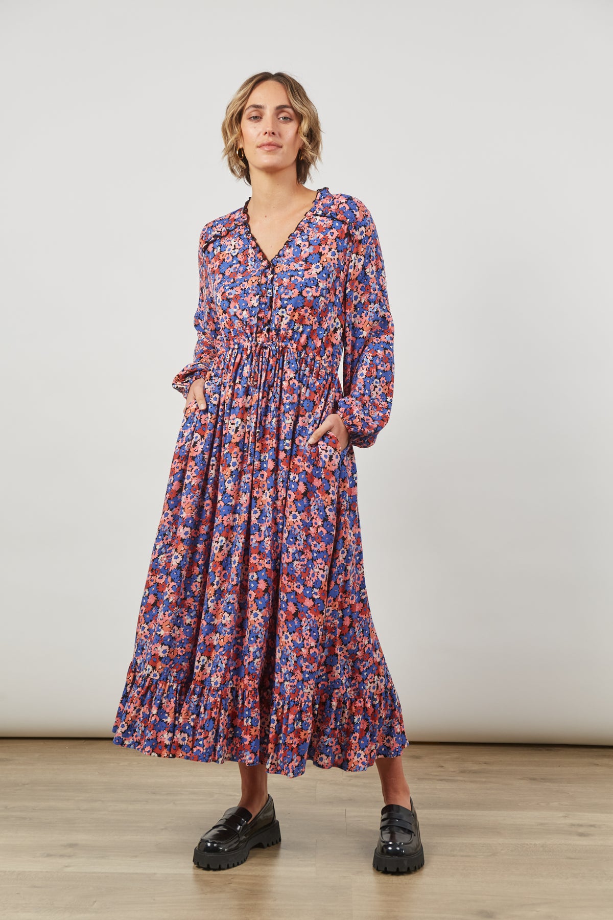 front view of women&#39;s maxi romance tiered dress  v-neck with detailing, gorgeous floral print all over, long sleeves 