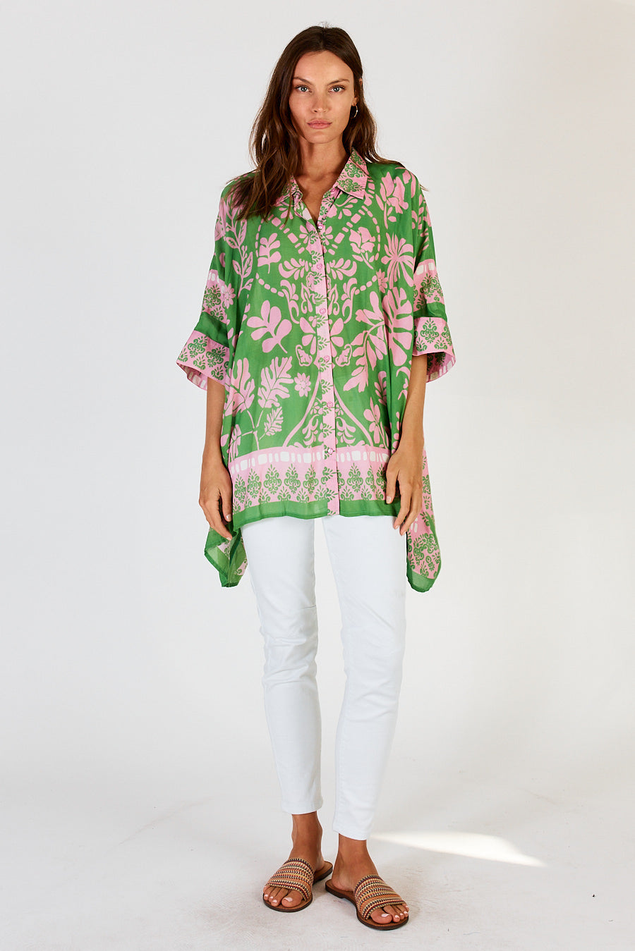 Carara Kaftan Shirt in Green with white pants, showing the high low hem.