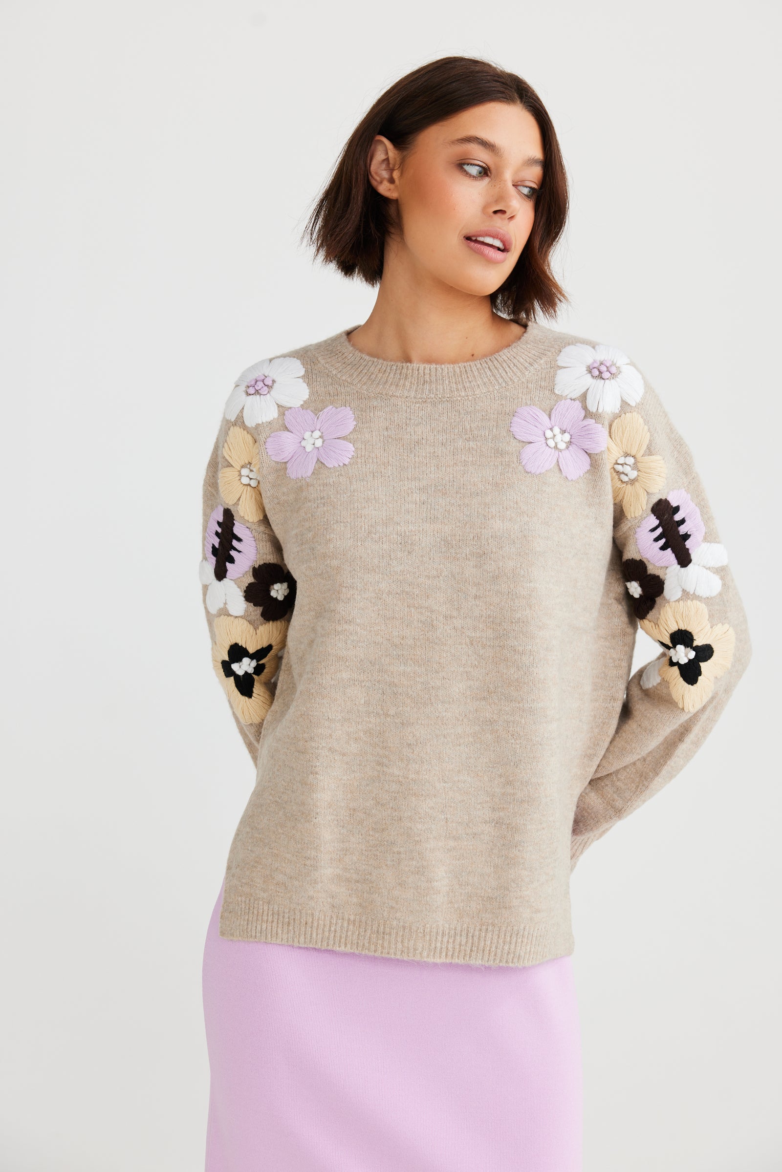 Knit jumper with lavender, white, navy and pale yellow flowers decorating the shoulders and arms