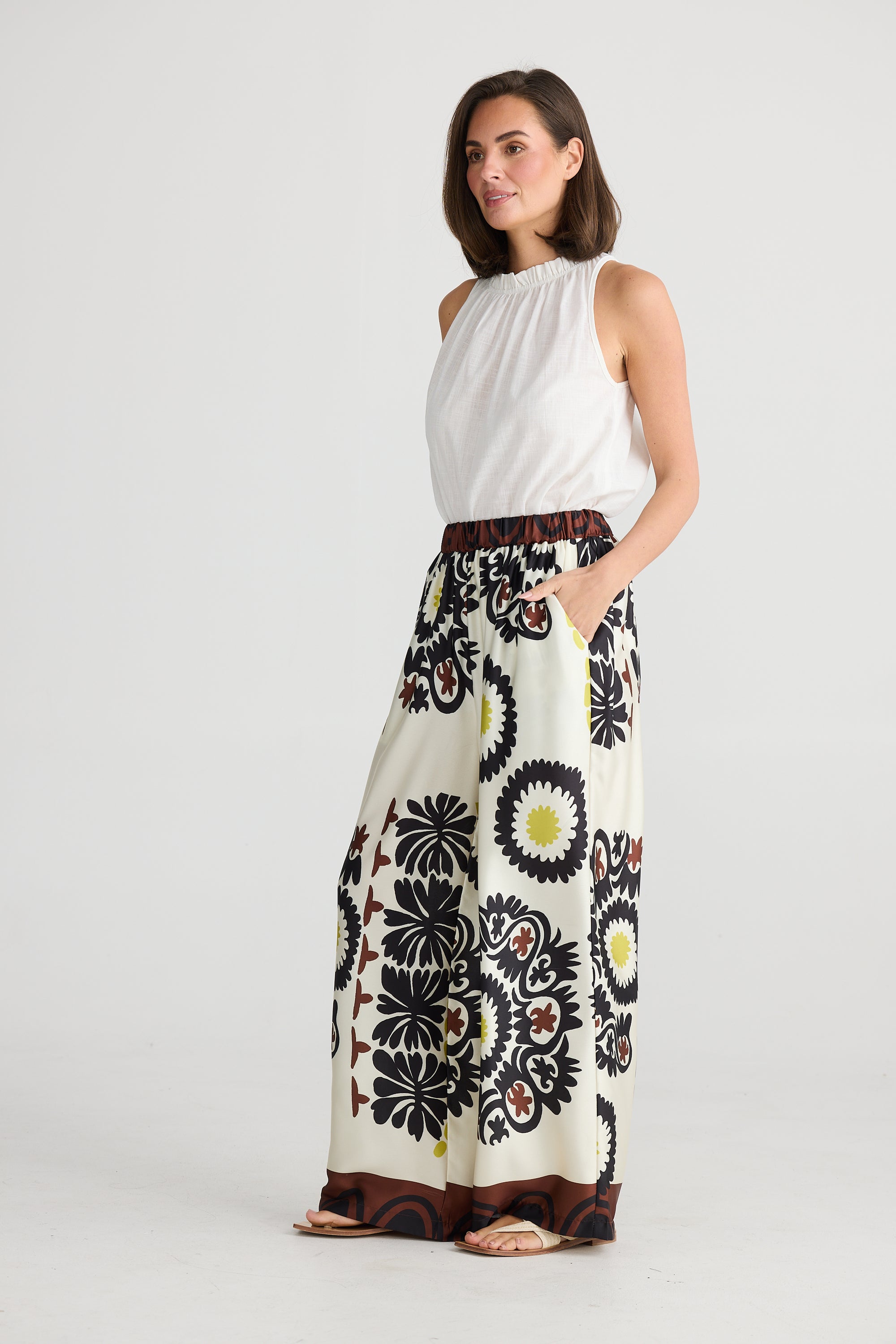 Side of Playa Trousers in geometric island print of yellow white brown and black.