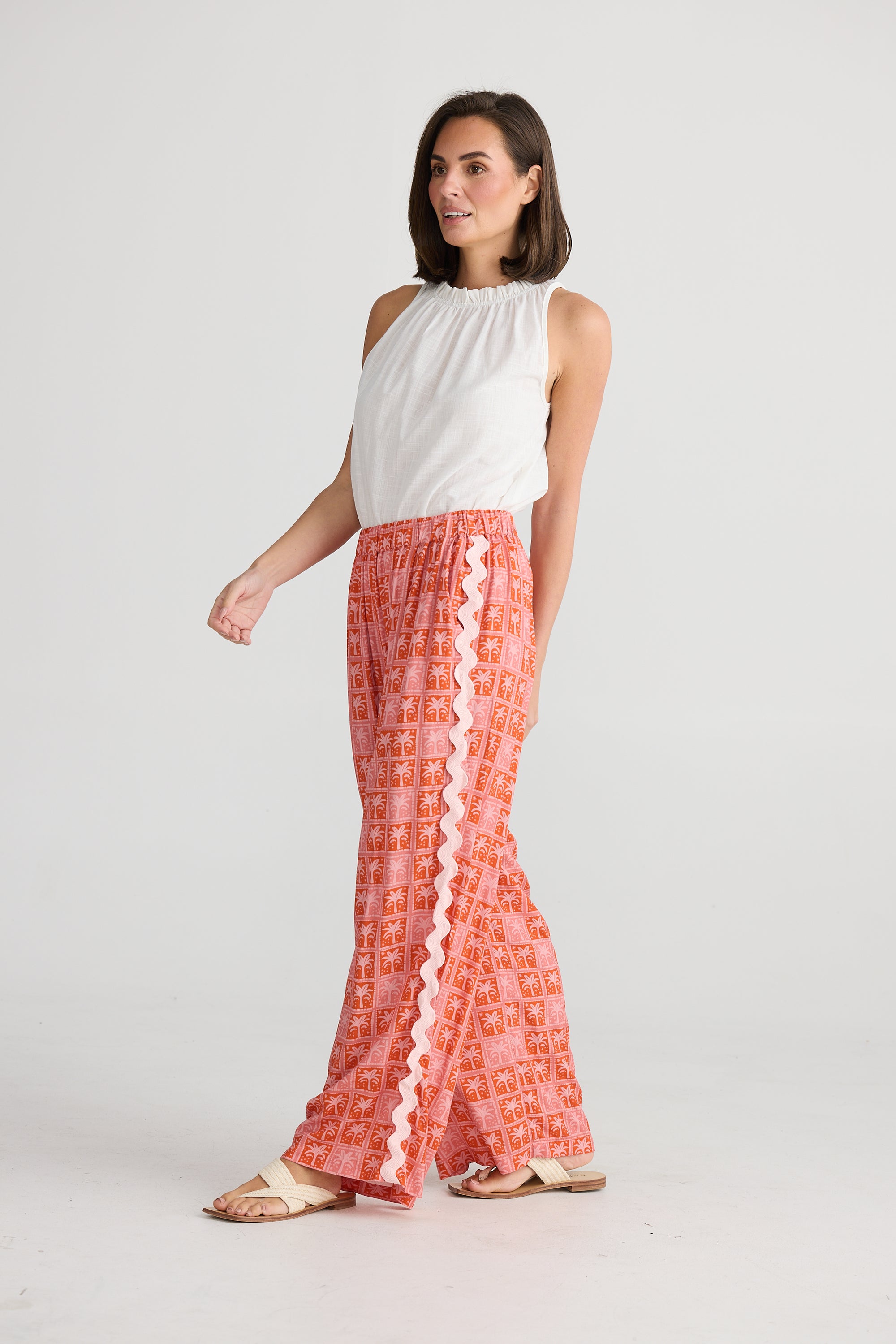 Side of women's disco palm Playa wide leg trousers in pink and red by Holiday.