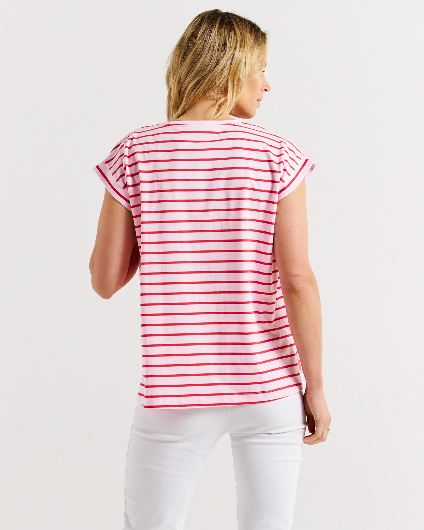 Model showing back of women's striped t-shirt in pink and red by Betty Basics.