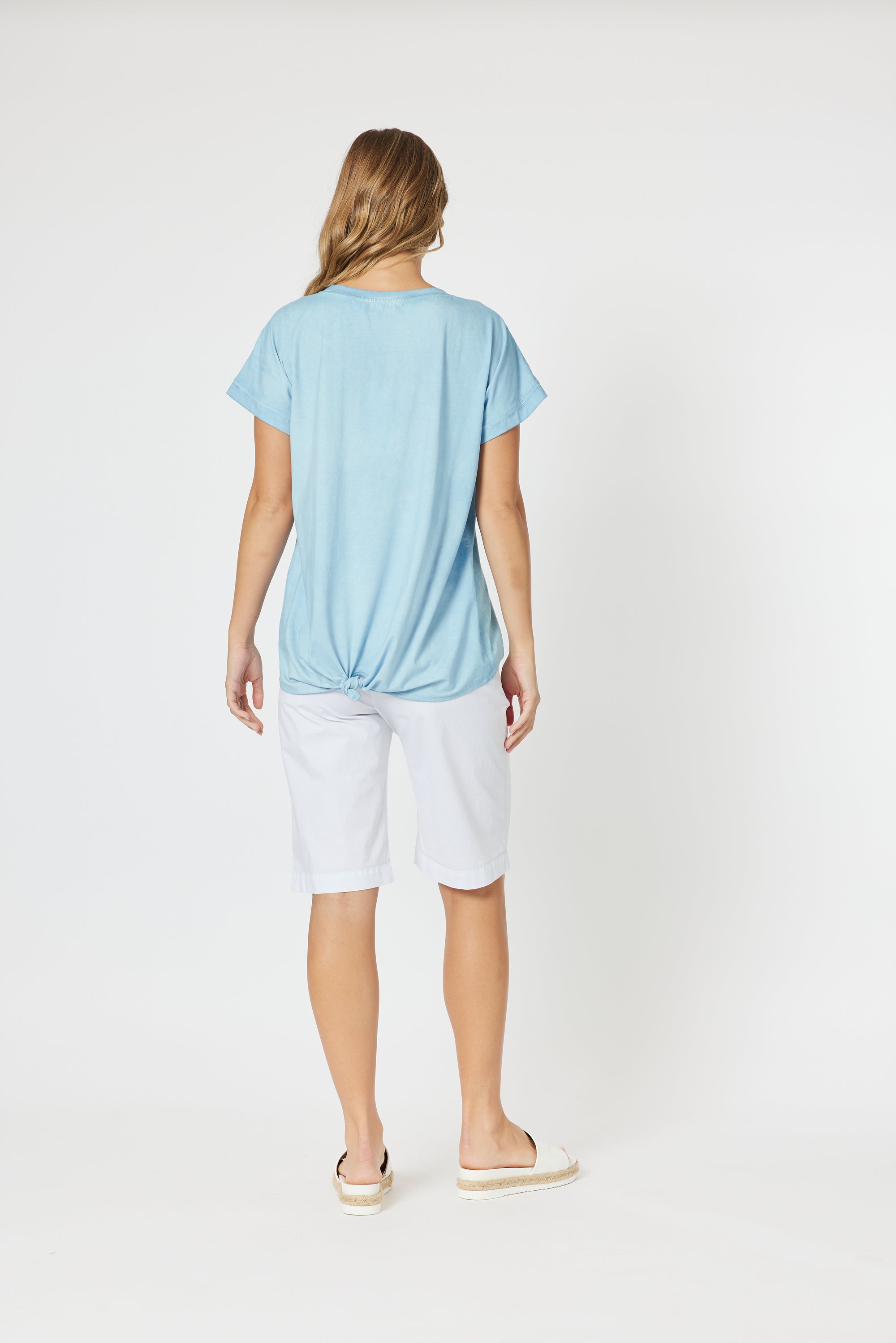 Back of Ladies blue tshirt with short sleeves and curved back hem.