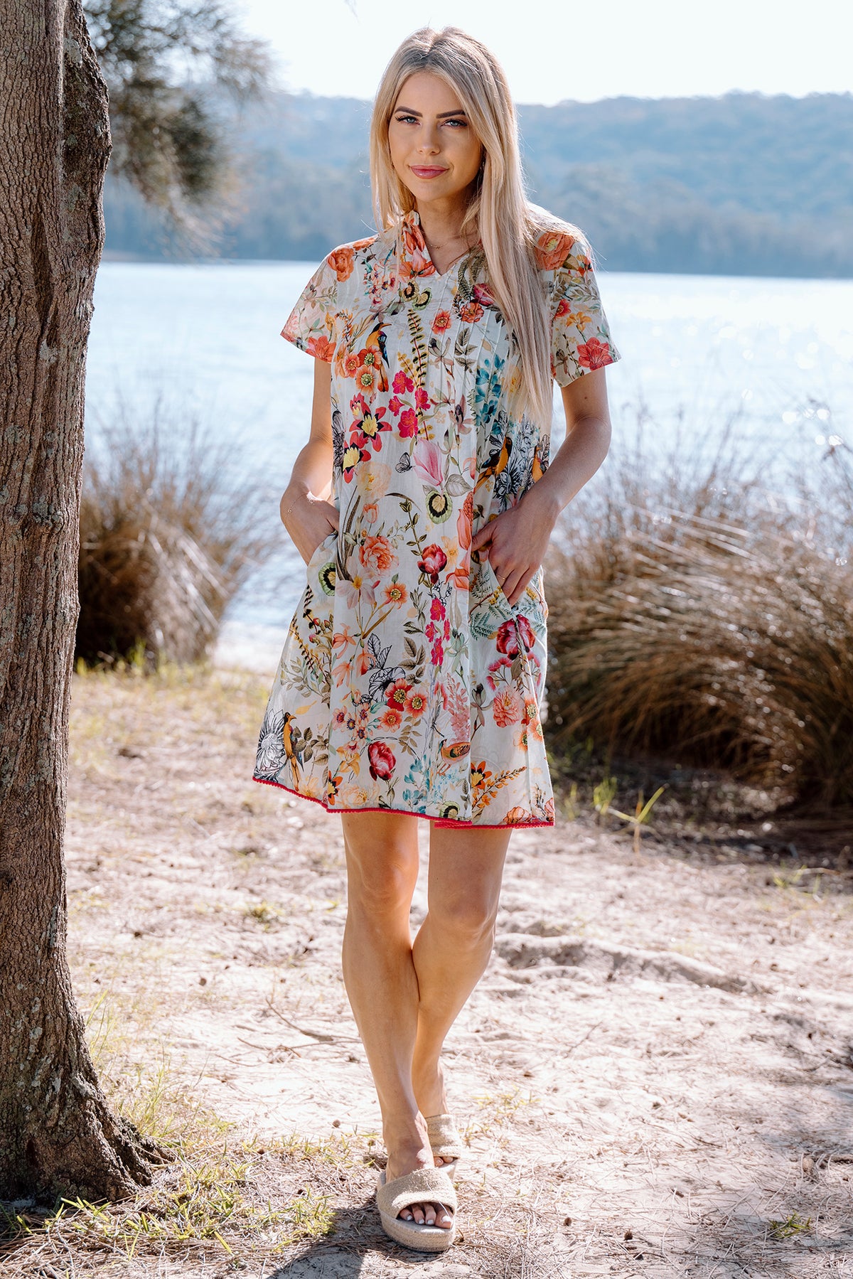 Cienna&#39;s White Kerala Cotton Midi Pinktuck Dress in Florals of pink, orange, red, yellow and blue.