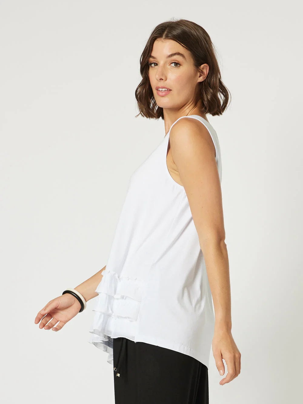 Side View of Sleeveless frill front hem white tank top by Clarity.