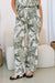 Close up of ladies green and natural leafy print full length linen trousers by Free Angel.