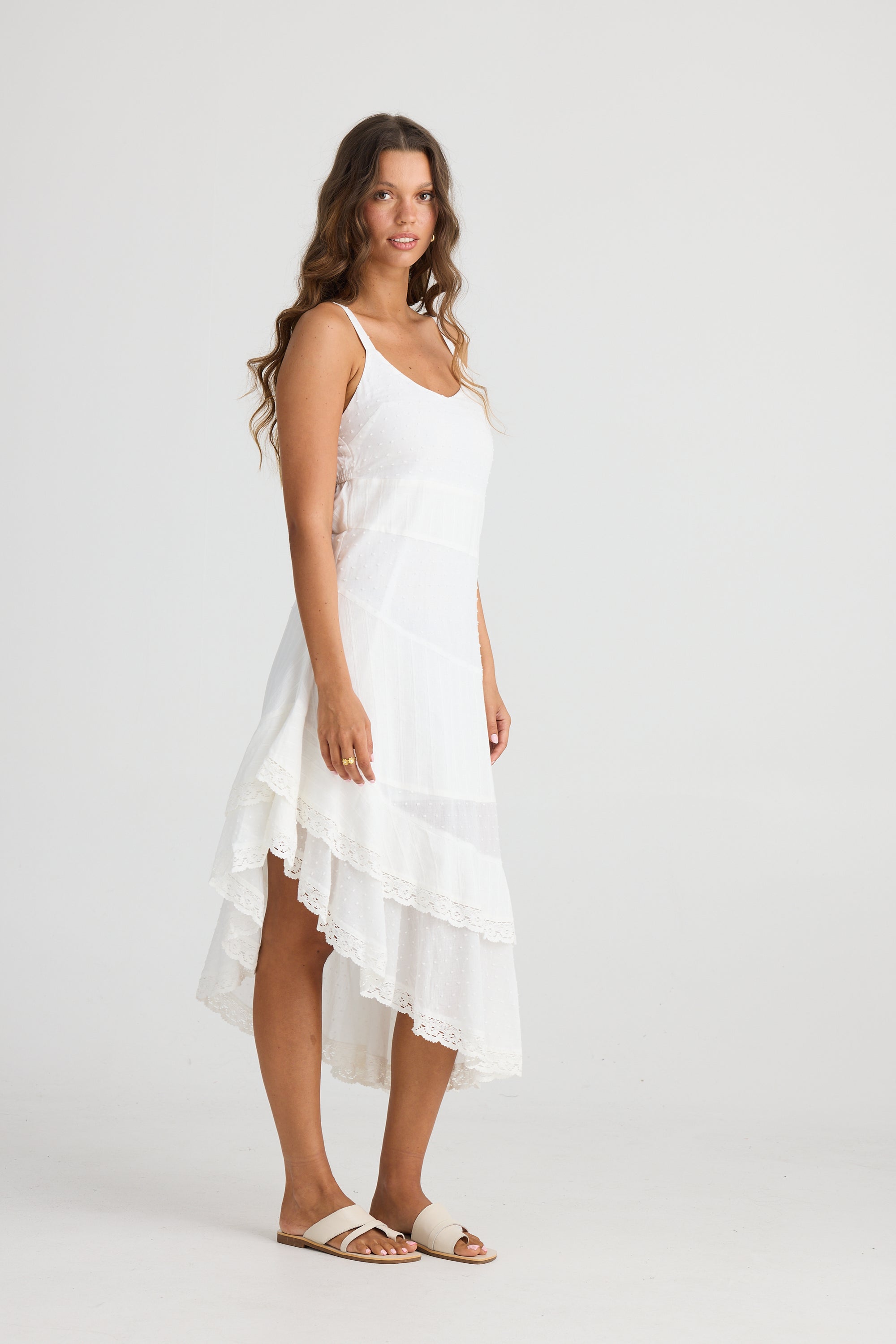 Anita Midi Dress in White with lace trim, straps, V-neck and asymmetrical hems in a cotton dobby material by Talisman.