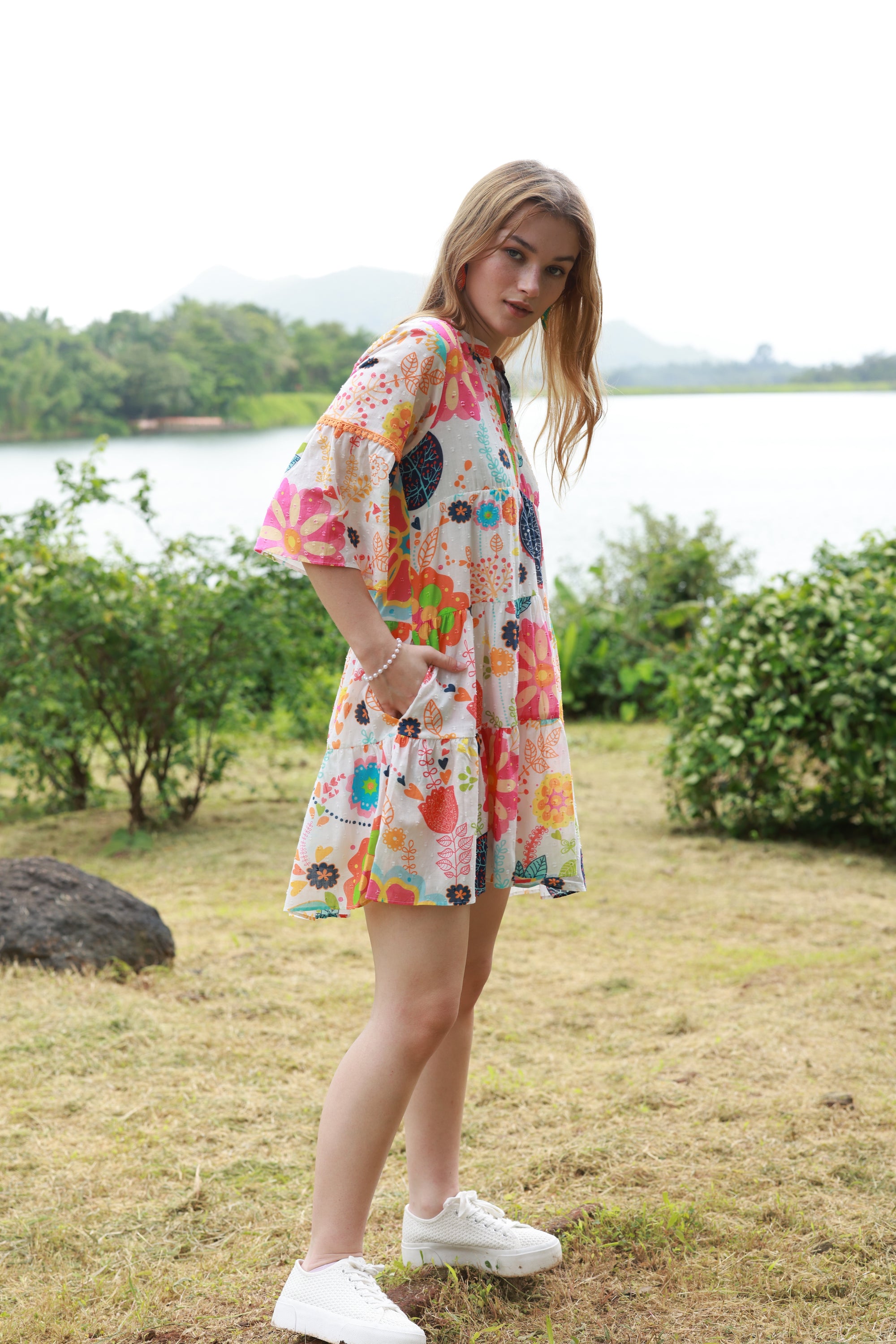 Side view of tiered wendy dress with elbow length sleeves, pockets and summer garden print in multi colours.