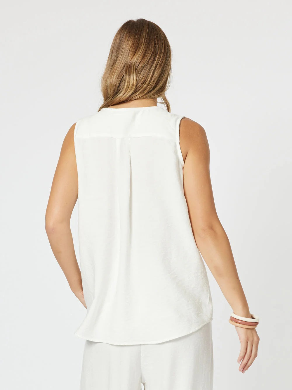 Back of Vacation Cami Top with slight tuck in middle, sleeveless with wide shoulders and curved hem.