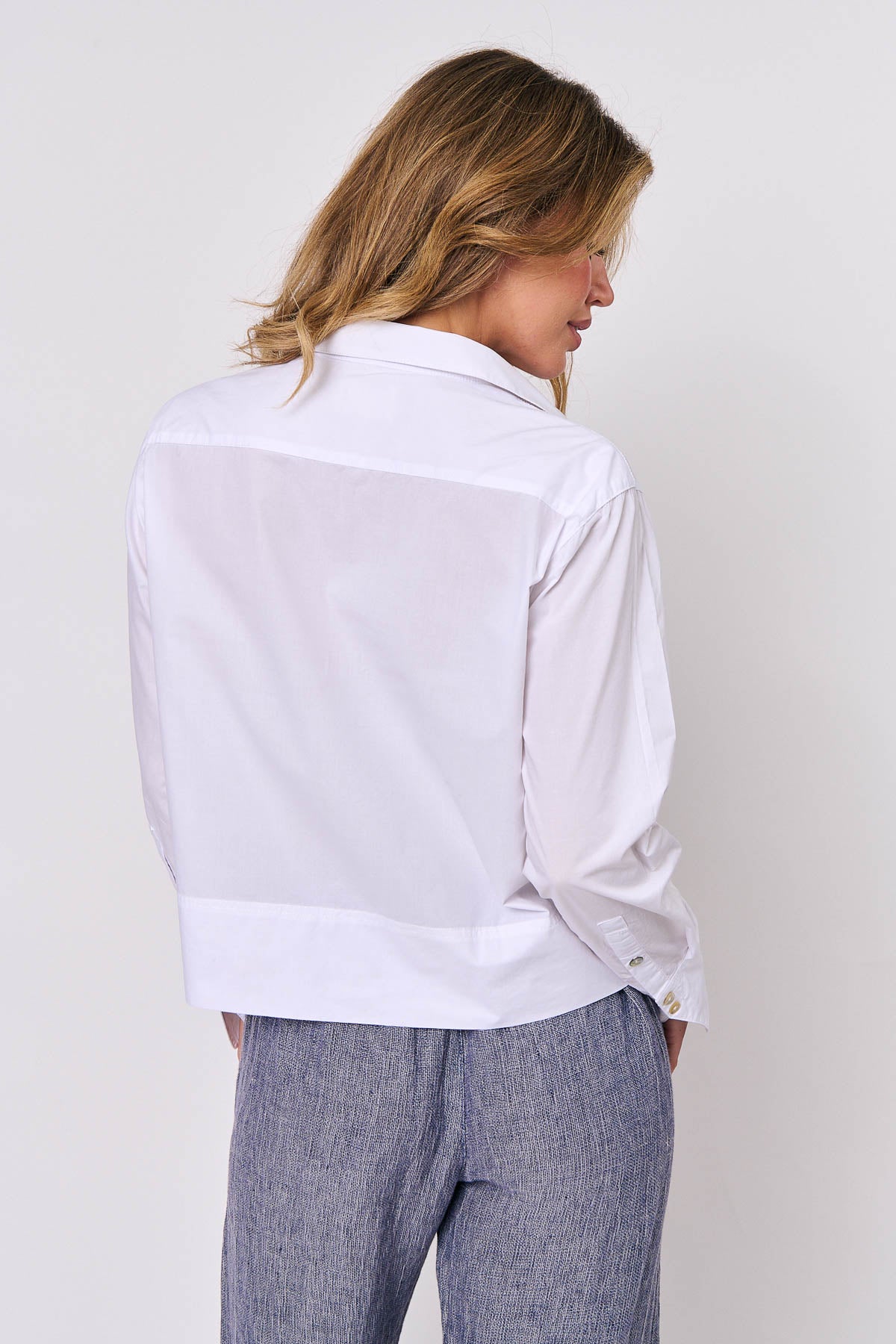 Back of relaxed fit straight hem white cotton long sleeve shirt by Naturals by O&J. 