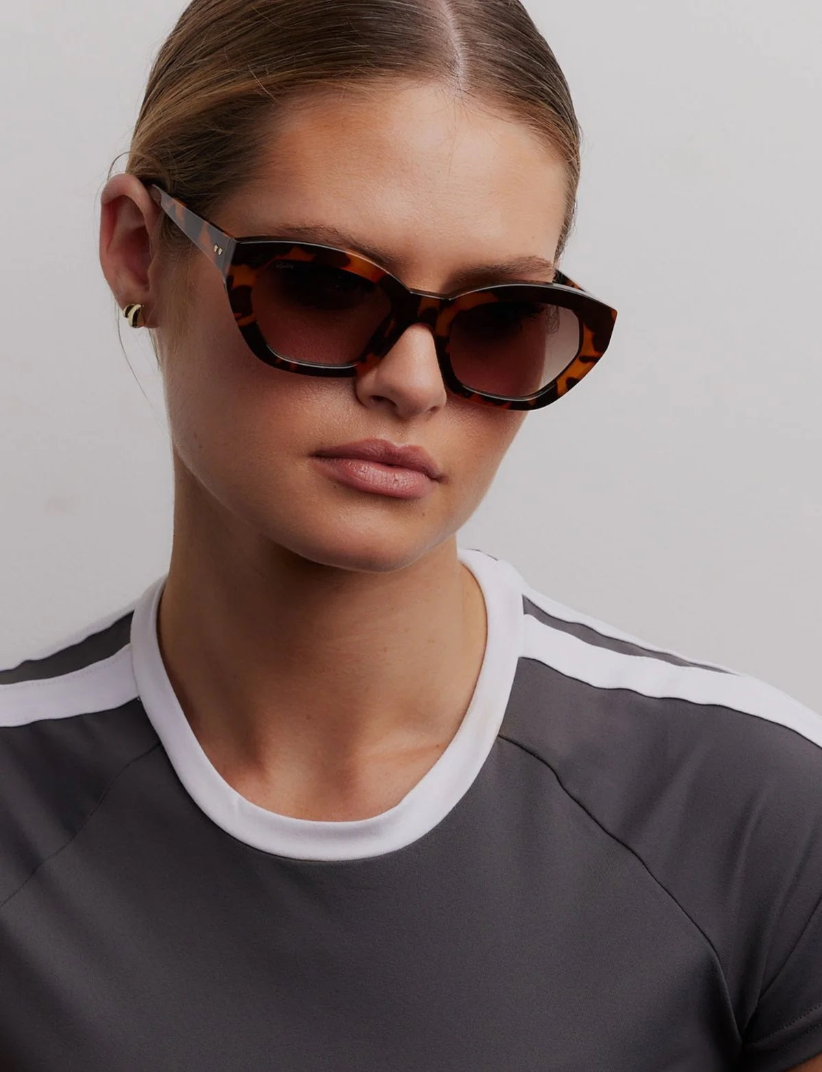 Model wearing tortoiseshell sunnies in a cat eye design by Reality Eyewear.