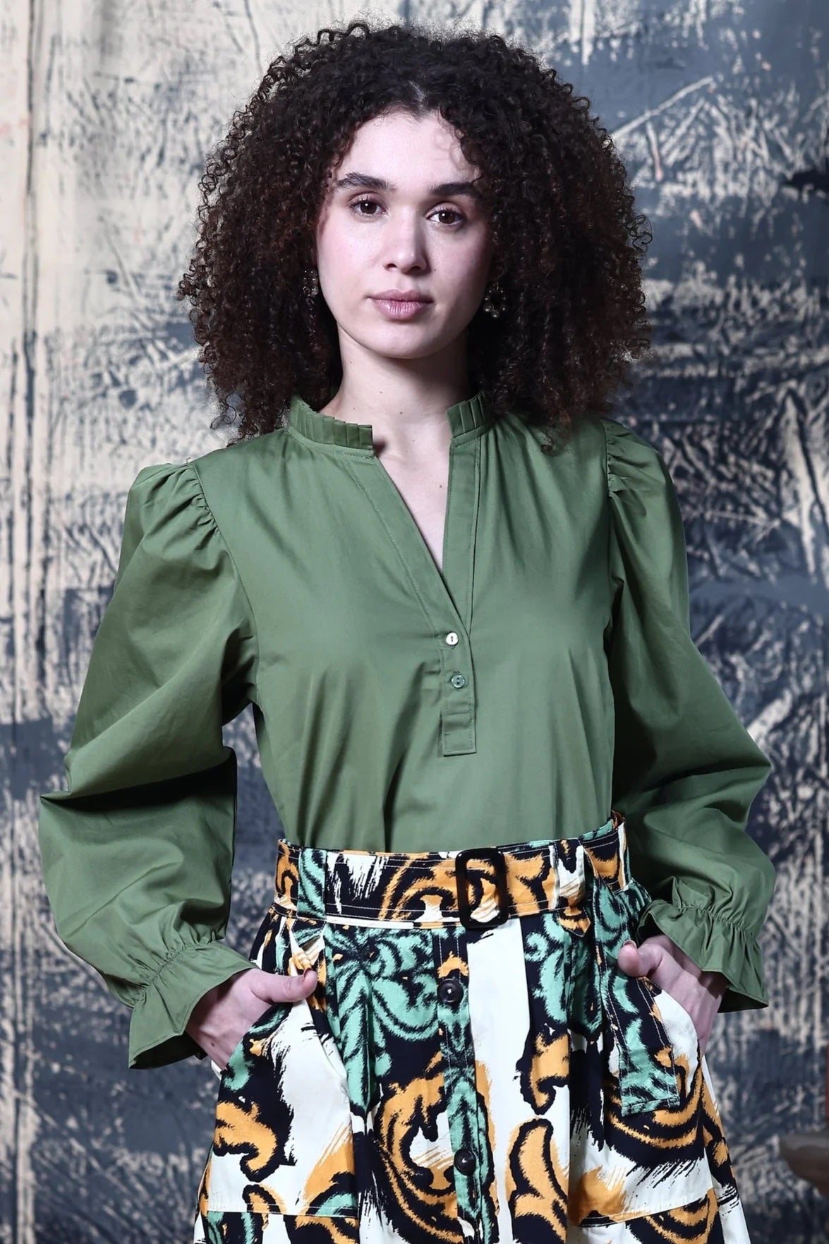 Maude Vivante&#39;s Rory Top in Olive Green with long sleeves, v-neck and stand up pleated collar.