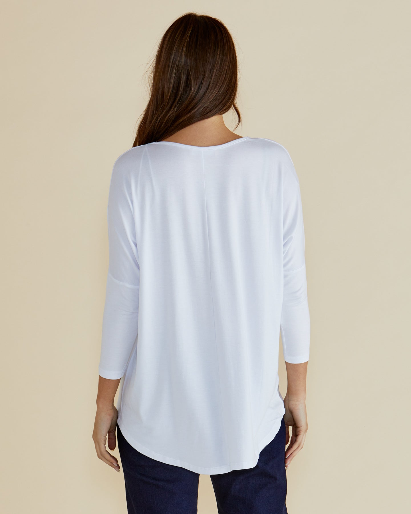 Back of white milan top with curved hem and drop shoulder.