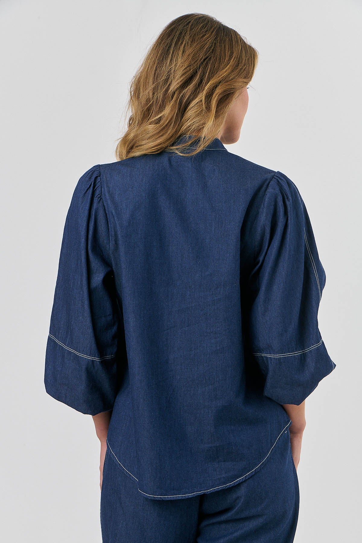 ladies blue shirt with  a curved hem, contrasting stitching and slight puff sleeves by Naturals by O&J.