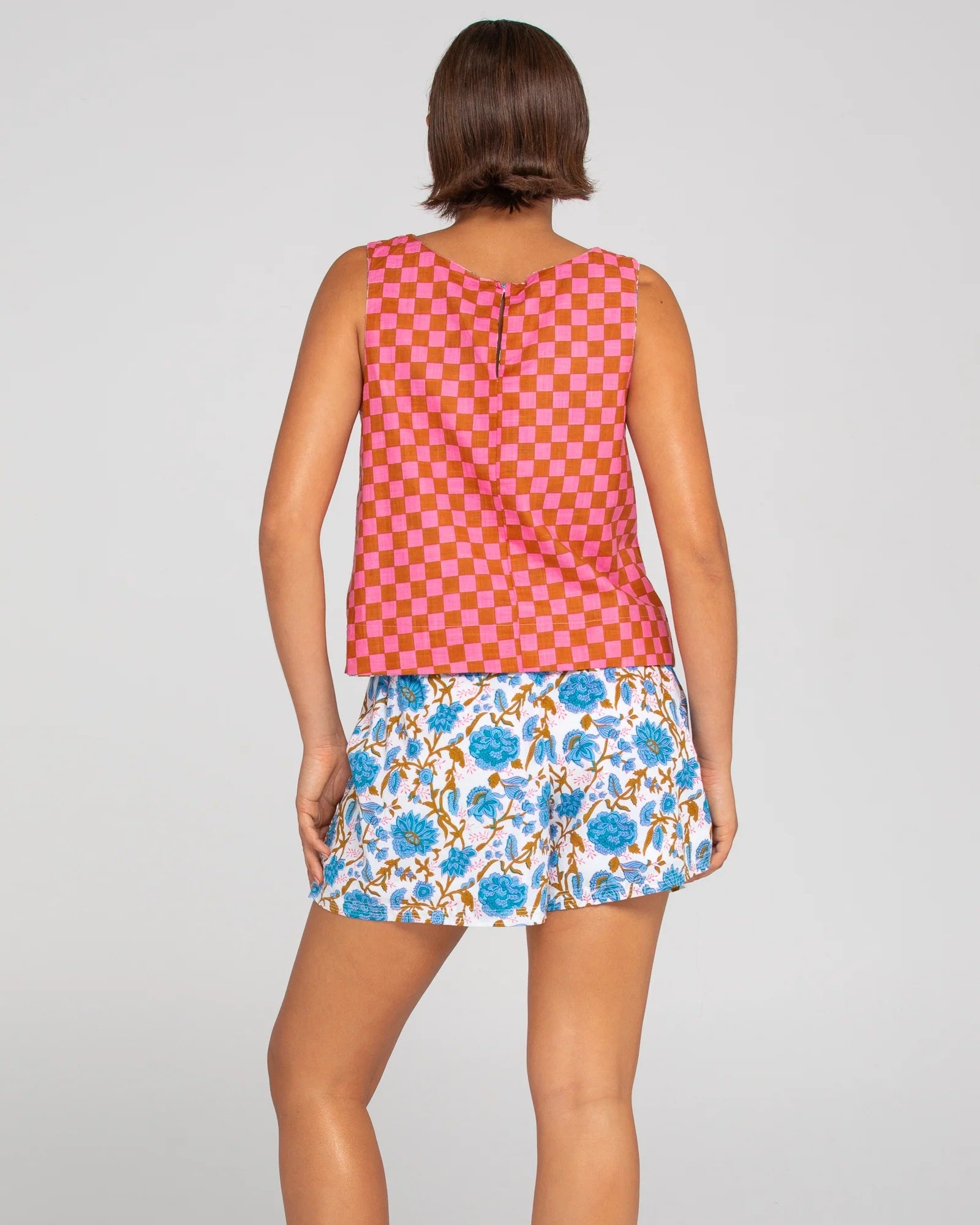 Back of sleeveless ladies top in red and pink square checkerboard print.