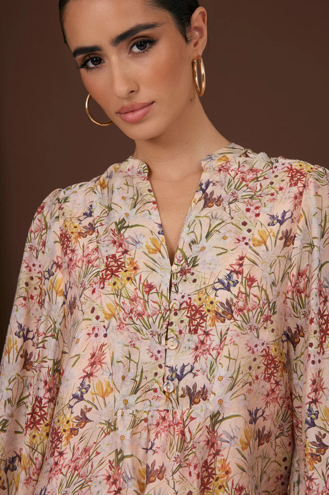 Close up of the Issy Belfast top in floral print with v-neck and buttons to tiering under bust, long sleeves and a grandpa collar by Adorne. 