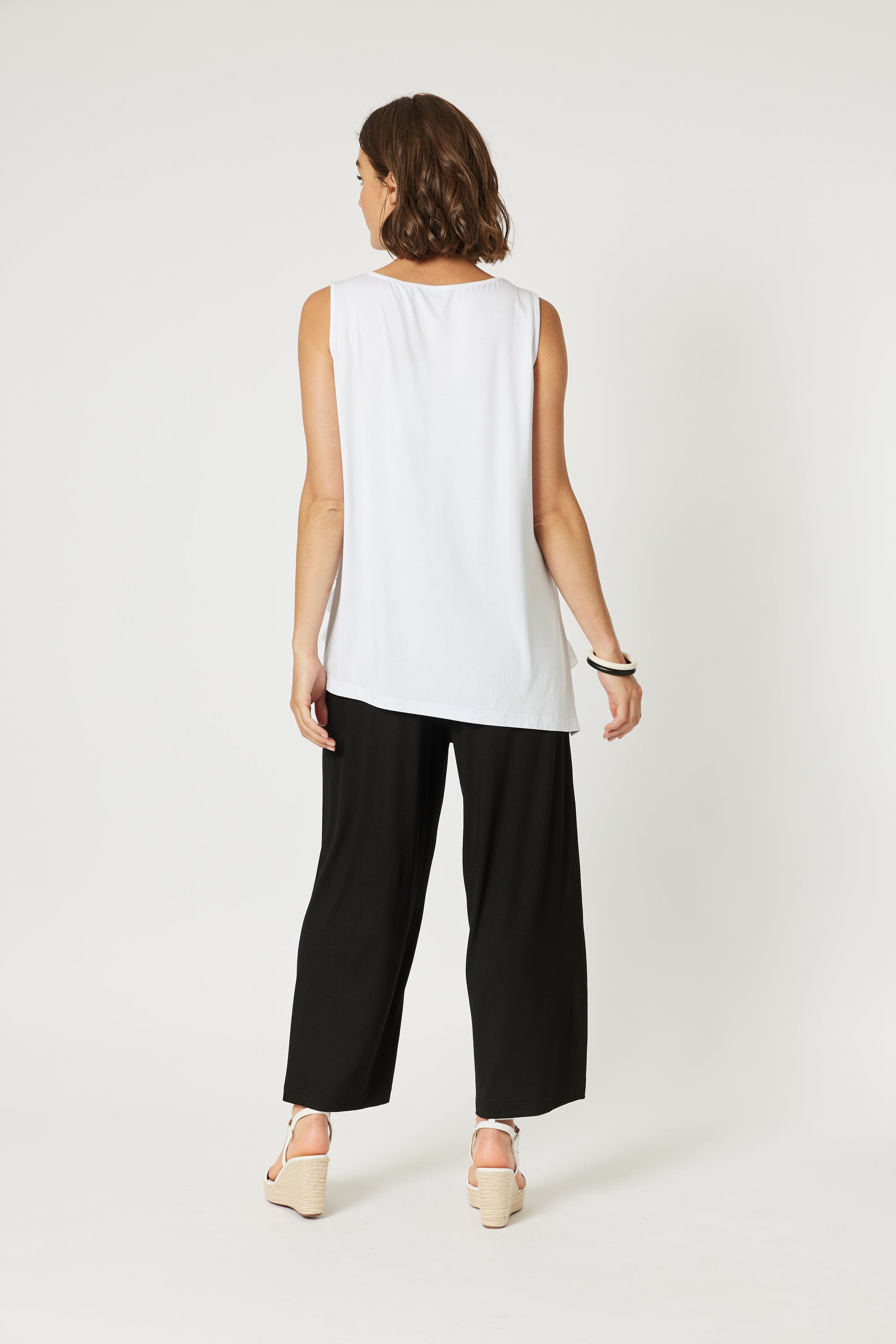 Back of the diagonal Ruffle Hem Cami Top by Clarity in white.