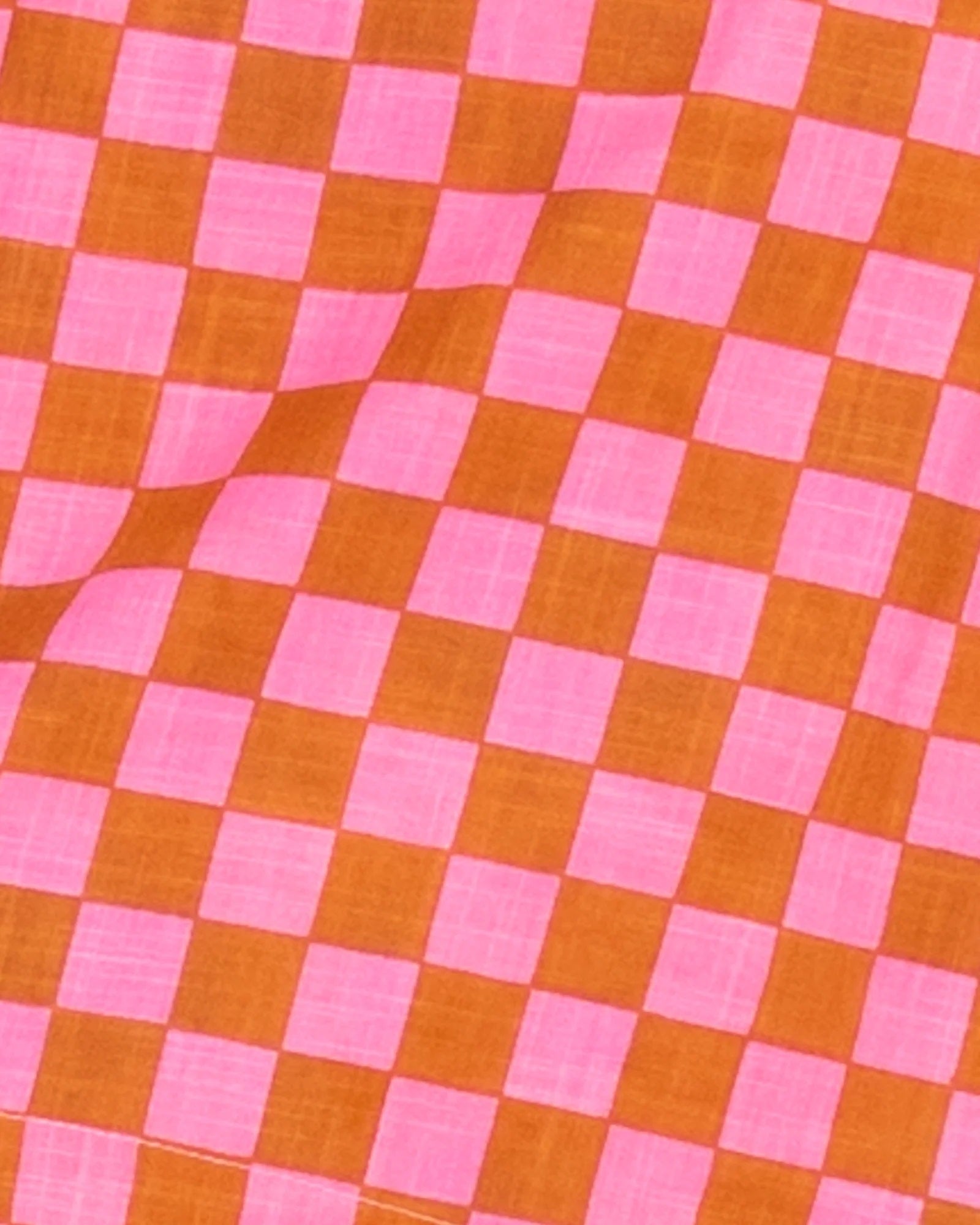 Close up of the pink and red checked print on the Hara Reversible Top.