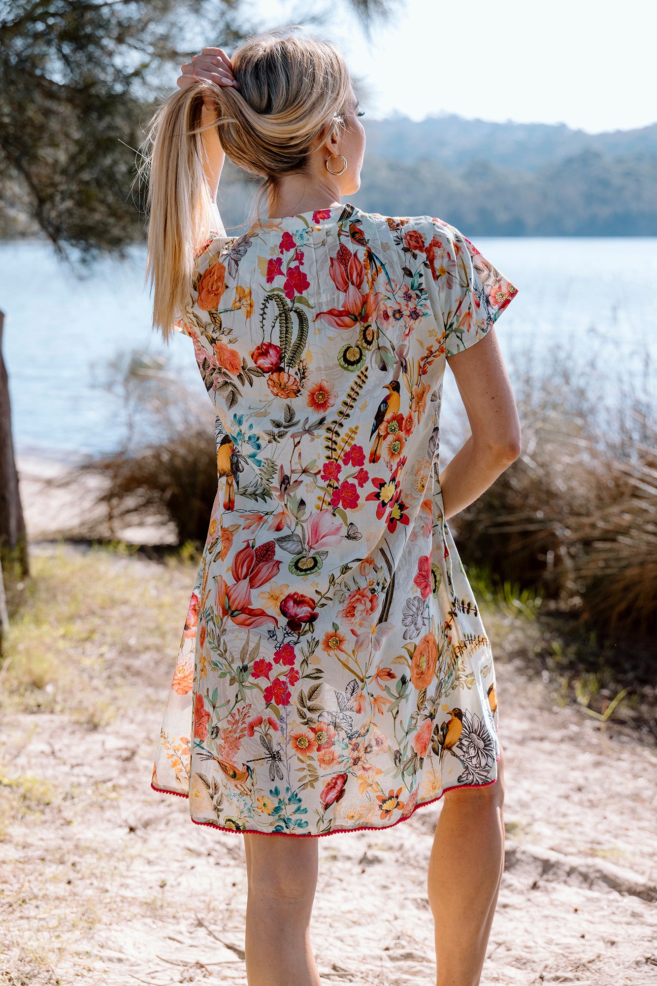 Cienna's White Kerala Cotton Midi Pinktuck Dress in Florals of pink, orange, red, yellow and blue.