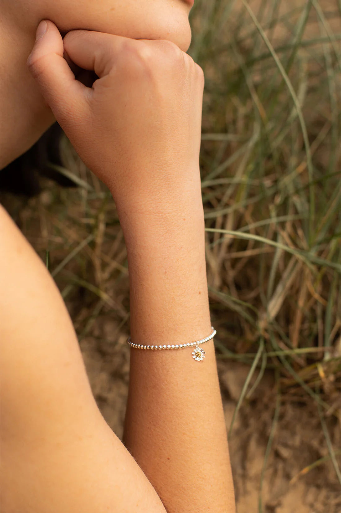 Model Wearing Flower charm beaded bracelet in silver by Estella Bartlett.